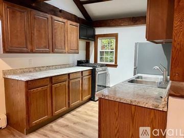 Andover apartment for rent - A kitchen with wooden cabinets and a granite countertop.