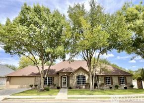 Schertz house for rent - A house with a brown roof and a front yard with trees.