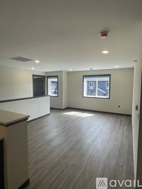 Altoona apartment for rent - A spacious room with a window and a wooden floor.