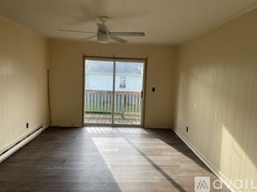 Oak Hill apartment for rent - A room with a ceiling fan and sliding glass doors leading to a balcony.