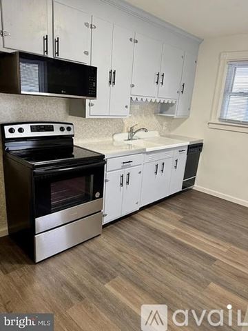 Palmyra apartment for rent - A kitchen with a black stove top oven and white cabinets.