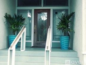 Tampa house for rent - A white railing leads up to a brown door with a glass panel.