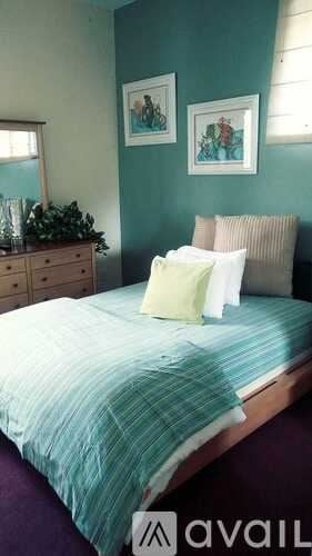 Tampa house for rent - A bed with a green bedspread and pillows in a room.