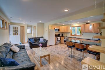 Wallingford house for rent - A living room with a black leather couch and a wooden coffee table.