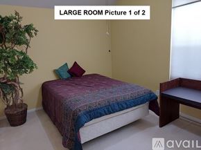 Houston house for rent - A bedroom with a bed, a bench, and a potted plant.