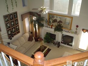 Houston house for rent - A living room with a couch, a television, and a fireplace.