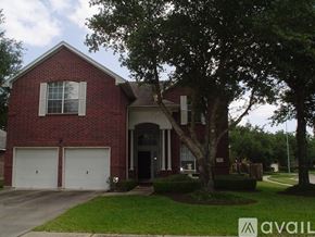 Houston house for rent - A red brick house with a tree in front.