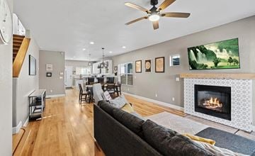 Denver house for rent - A living room with a fireplace and a painting of a waterfall on the wall.