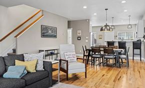 Denver house for rent - A living room with a grey couch and a sign that says "Tenants please leave".