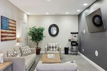 Westerville apartment for rent - A living room with a large couch, a coffee table, and a television on the wall.