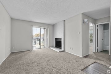 Weatherford apartment for rent - A sparsely furnished living room with a fireplace and sliding glass doors.