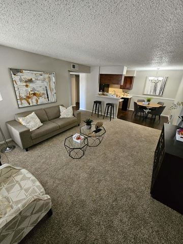 Denton apartment for rent - A living room with a couch, chair, and a painting on the wall.