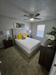 Denton apartment for rent - A bedroom with a bed, nightstands, and a ceiling fan.