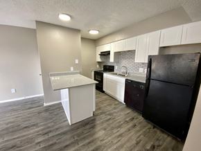 Denton apartment for rent - A kitchen with a black refrigerator and white cabinets.