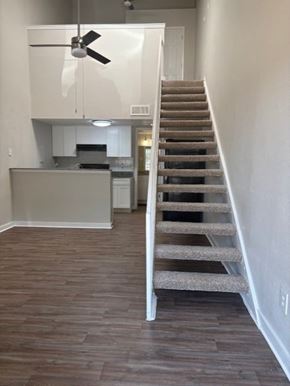 Fort Worth apartment for rent - A staircase with a carpeted runner leads up to a kitchen area.