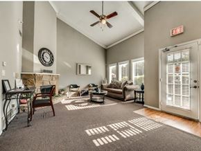 Fort Worth apartment for rent - A living room with a fireplace and a ceiling fan.