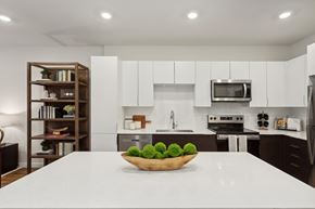 Woodbridge apartment for rent - A bowl of green apples sits on a white countertop in a modern kitchen.
