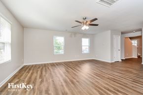 Kernersville house for rent - A spacious room with wooden flooring and a ceiling fan.