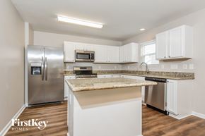 Kernersville house for rent - A kitchen with a granite countertop and stainless steel appliances.