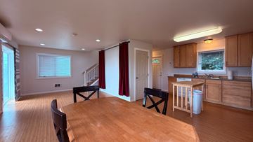 Sitka house for rent - A kitchen with wooden floors and a dining table with chairs.
