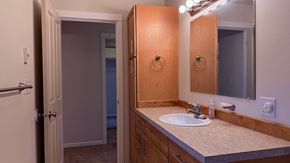 Sitka house for rent - A bathroom with a sink, mirror, and light.