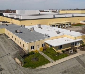 Lima apartment for rent - A large industrial building with a yellow and white exterior and a grey roof.