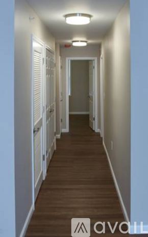 Cincinnati apartment for rent - A long hallway with white walls and wood floors.