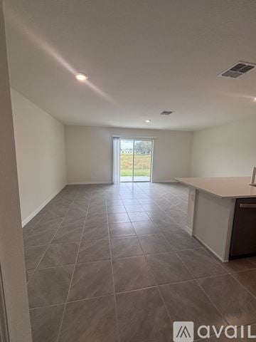 Wildwood townhouse for rent - A spacious room with tiled flooring and a kitchen area.