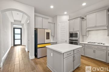 San Antonio house for rent - A modern kitchen with white cabinets and a central island.