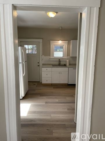 Colorado Springs house for rent - A kitchen with white cabinets and a wooden floor.