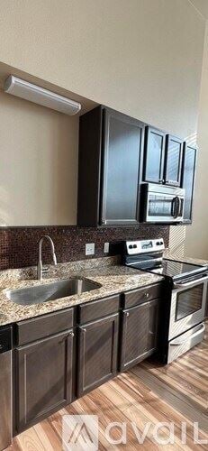 Waco apartment for rent - A kitchen with black cabinets and a granite countertop.