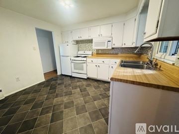 Pittsburgh house for rent - A kitchen with a white fridge, microwave, and oven.