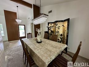 Plano house for rent - A dining room with a table set for two and a chandelier hanging from the ceiling.