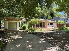 Plano house for rent - A house with a garage is surrounded by trees.