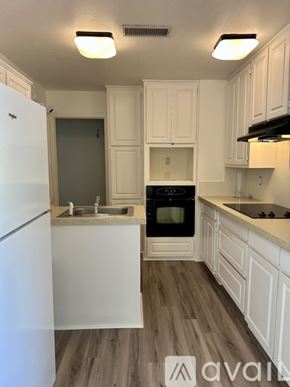 Plano house for rent - A kitchen with white cabinets and a white fridge.