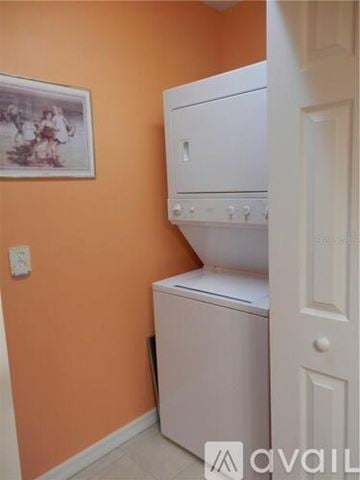 Bradenton townhouse for rent - A white dishwasher is in a kitchen with orange walls.