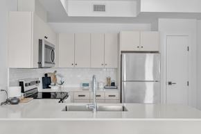 Winnipeg apartment for rent - A modern kitchen with a stainless steel refrigerator and white cabinets.