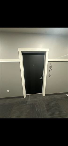 Calgary house for rent - A black door is in a white frame.