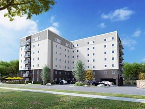 Winnipeg apartment for rent - A modern apartment building with a parking lot in front.