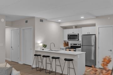 Winnipeg apartment for rent - A modern kitchen with white cabinets and stainless steel appliances.