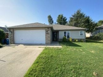 Bentonville house for rent - A house with a garage door and a driveway.