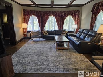 La Porte house for rent - A living room with a grey rug and black leather furniture.