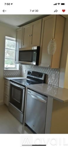 West Palm Beach house for rent - A kitchen with a stove top oven and microwave.
