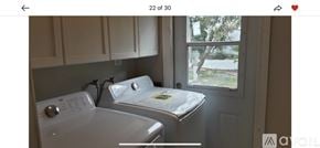 West Palm Beach house for rent - A white washing machine and dryer in a small laundry room.
