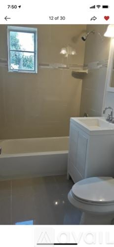 West Palm Beach house for rent - A white toilet in a bathroom with a window above it.