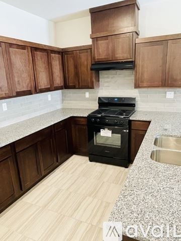 El Paso apartment for rent - A kitchen with wooden cabinets and a black stove top oven.