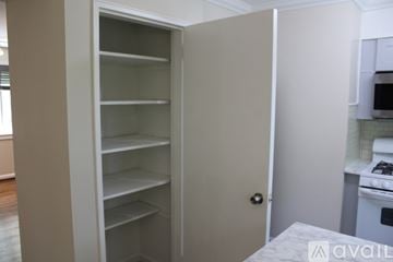 Hyattsville house for rent - A kitchen with white cabinets and appliances, a white island, and a white door leading to another room.