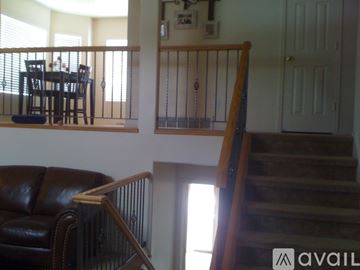 Layton house for rent - A living room with a brown leather couch and a dining table with chairs.