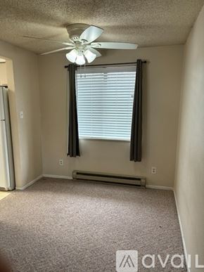 Loveland apartment for rent - A room with a carpeted floor, a ceiling fan, and a window with blinds.
