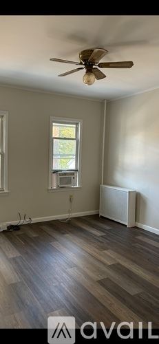 Scranton house for rent - A room with a ceiling fan and a window with a view of trees.